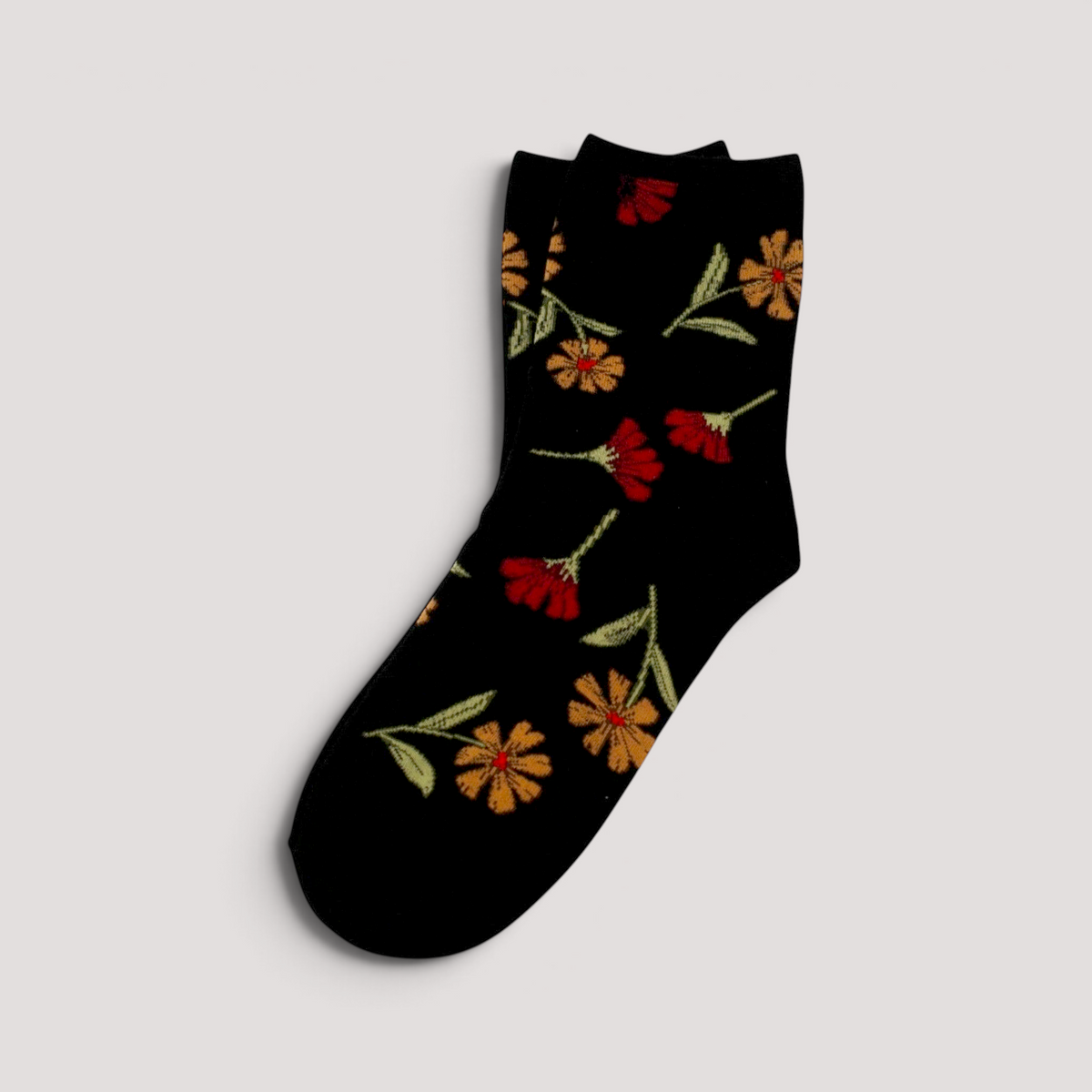 SUNMOOL black crew socks featuring a vibrant mustard and red wild flower botanical print pattern.