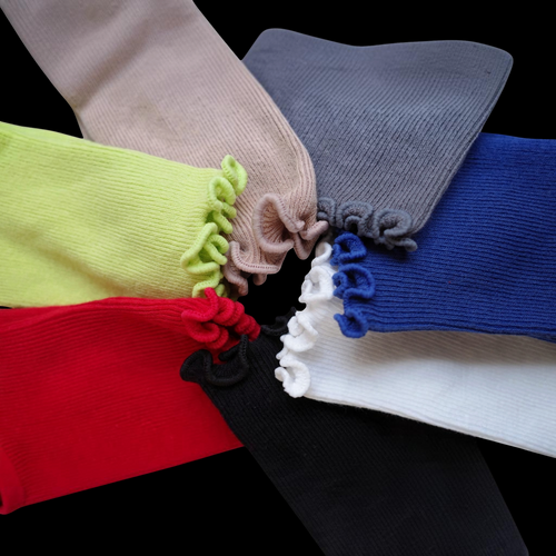 SUNMOOL loose-fit socks in a variety of vivid colors featuring playful curly ruffle cuffs on a black background