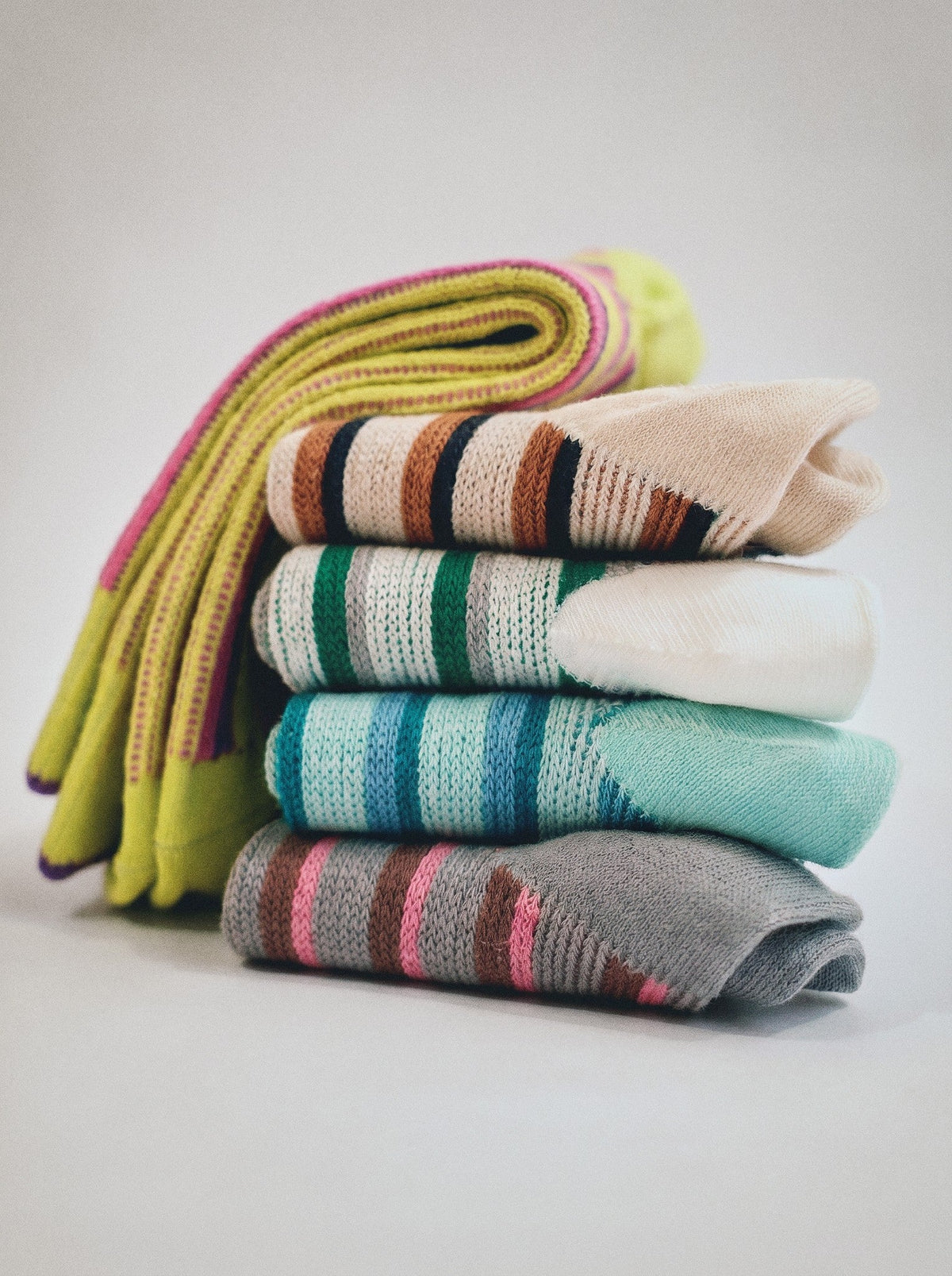 SUNMOOL dual stripe socks in a stacked set featuring various colors like yellow, ivory, green, and grey.