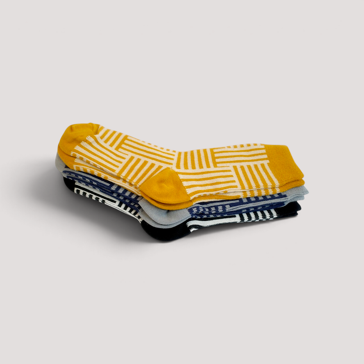 SUNMOOL set of three cotton socks featuring mustard, grey, and black geometric line drawing patterns.