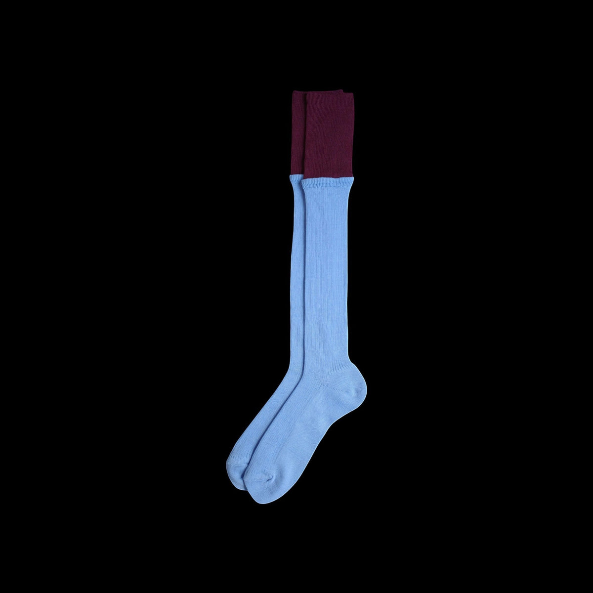 SUNMOOL sky blue knee-high socks with a contrasting deep burgundy dip-dyed ribbed cuff on a black background.