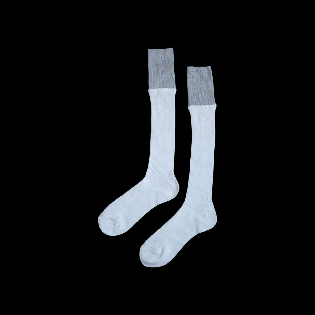 SUNMOOL white knee-high socks with a grey dip-dyed ribbed cuff on a black background.