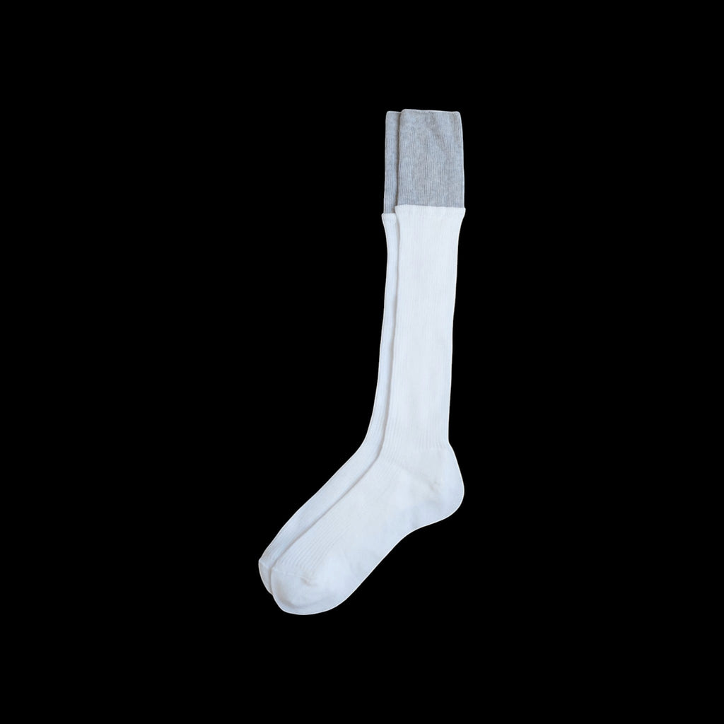 SUNMOOL white knee-high socks with a grey dip-dyed ribbed cuff on a black background.